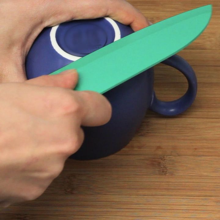 afilar un cuchillo sin filo en el borde de una taza