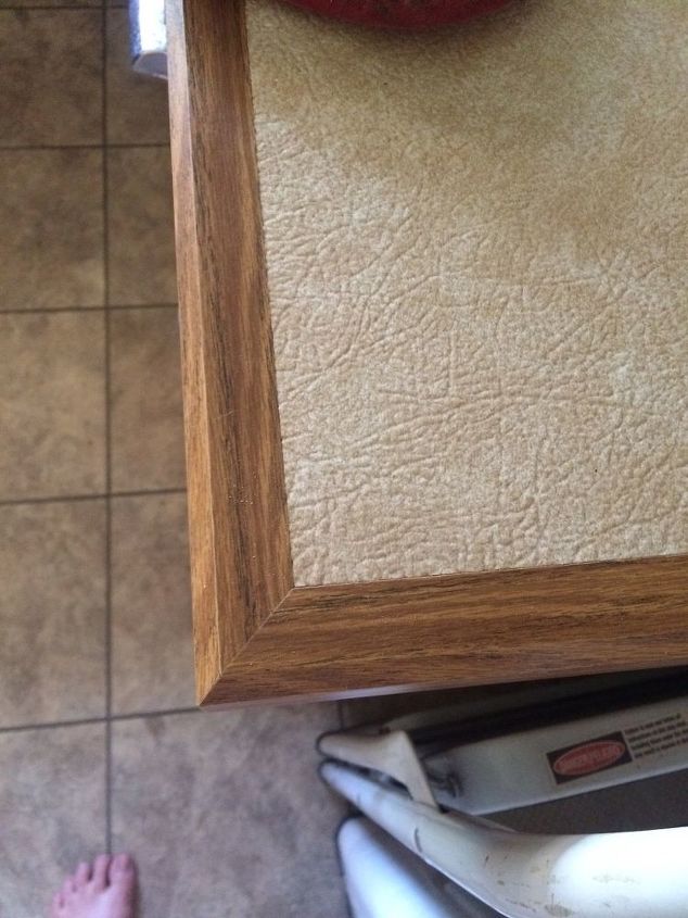 q my kitchen and i need your help can you give some very cheap ideas , countertops, kitchen cabinets, kitchen design, This is the countertop To me it looks like flooring framed in oak It is hard to get clean and is rough like a textured vinyl floor would be