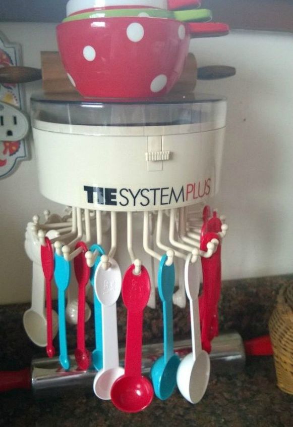 13 storage ideas that will instantly declutter your kitchen drawers, Hang measuring spoons on a tie rack