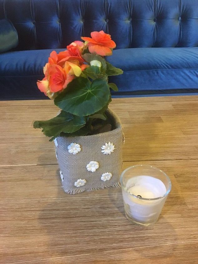 uma caixa de leite transformada em um vaso de flores