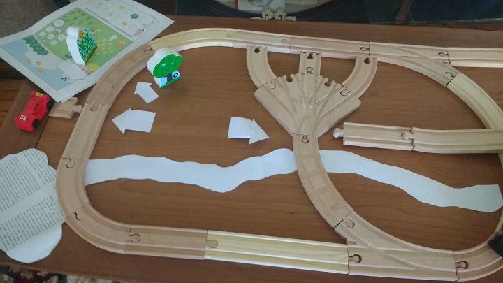 turn a dumpster coffee table into a child s personalized play table, Lay out and trace around railroad tracks