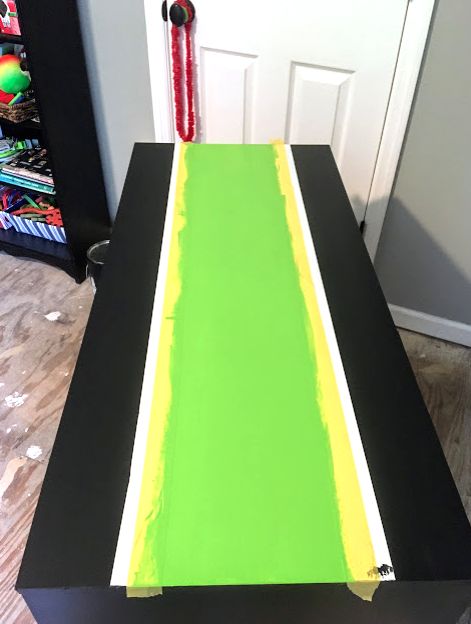 reforma da mesa de um menino interpolado com uma faixa verde neon