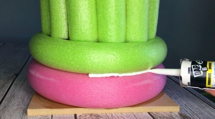 grab some pool noodles and copy these 3 ideas, Step 6 Place ring on wood and begin caulking