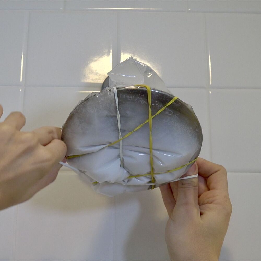 s 30 essential hacks for cleaning around your home, Make Your Showerhead Sparkle With Vinegar