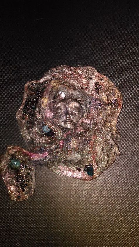 ethereal face of a woman on a brooch pin