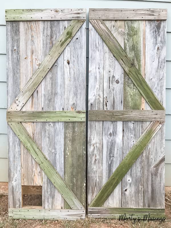 one of a kind sliding barn door with a pet door built in it