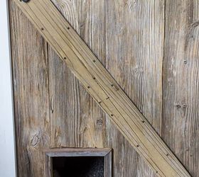 one of a kind sliding barn door with a pet door built in it