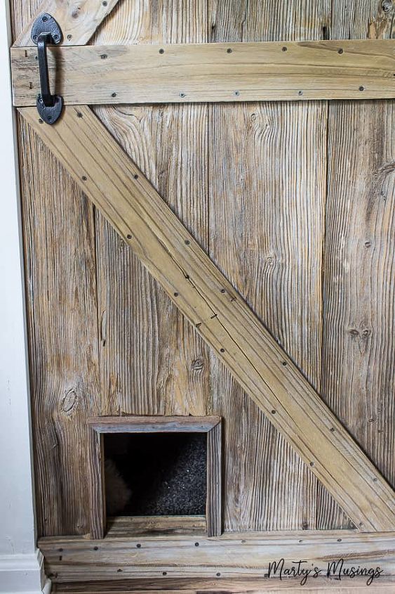 one of a kind sliding barn door with a pet door built in it