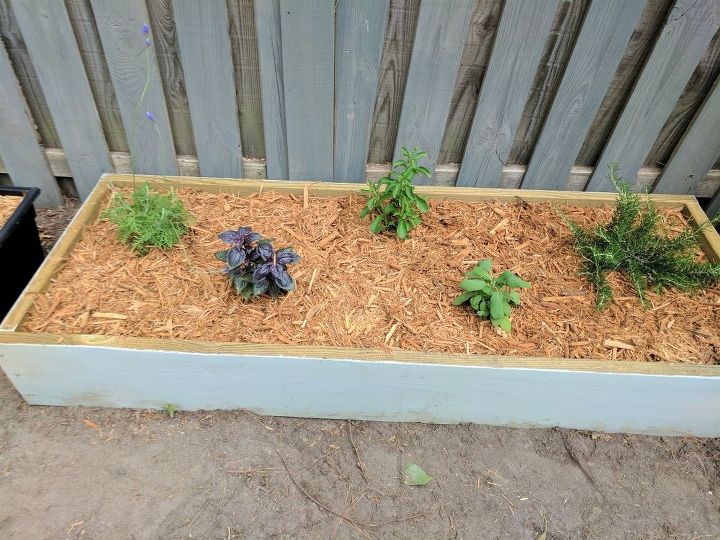 build two raised herb gardens for less than 50, One of the newly mulched beds