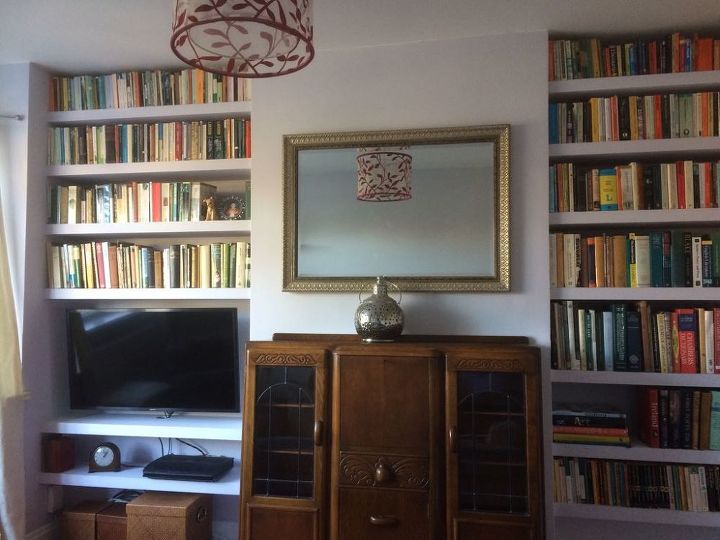 organize livros e tv com uma estante embutida na alcova