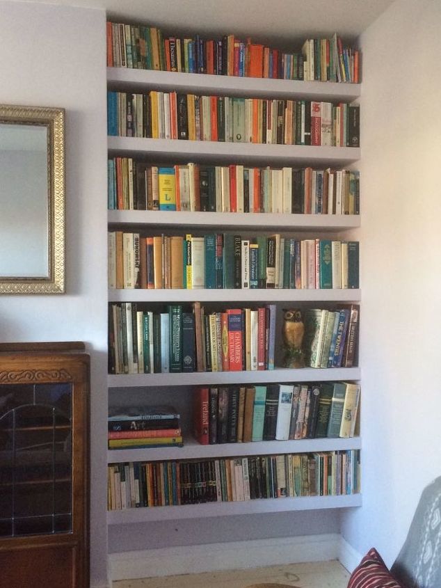 organize livros e tv com uma estante embutida na alcova