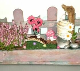 a palette is transformed into a fairy garden with mushrooms and candle