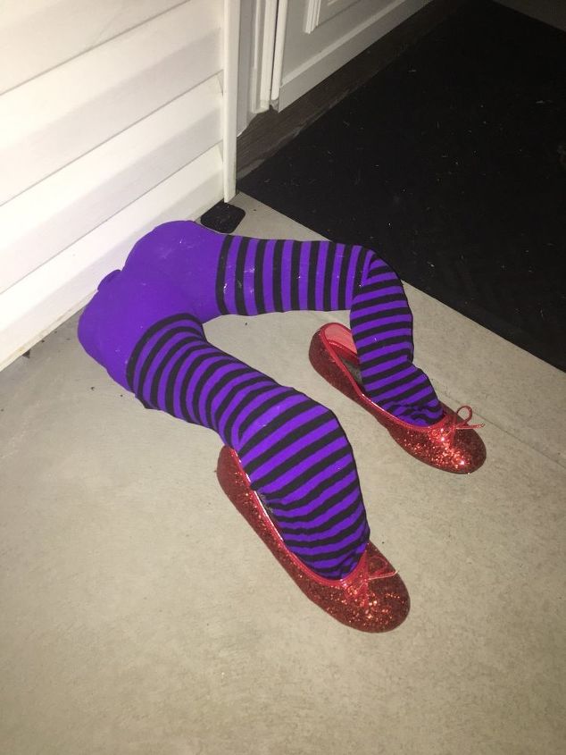 decore sua casa no halloween com as pernas da bruxa do mgico de oz, As pernas de bruxa com os chinelos de Dorothy na porta da garagem