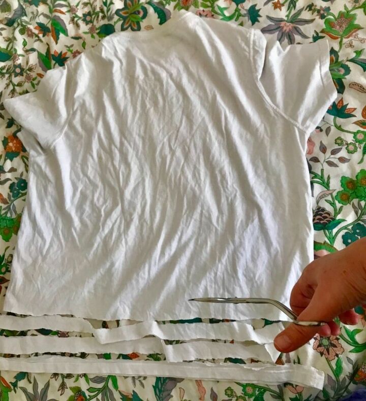 como hacer una hermosa alfombra de trapo haciendo un telar con un aro de hula, Corta una camiseta vieja en tiras de un cent metro de ancho