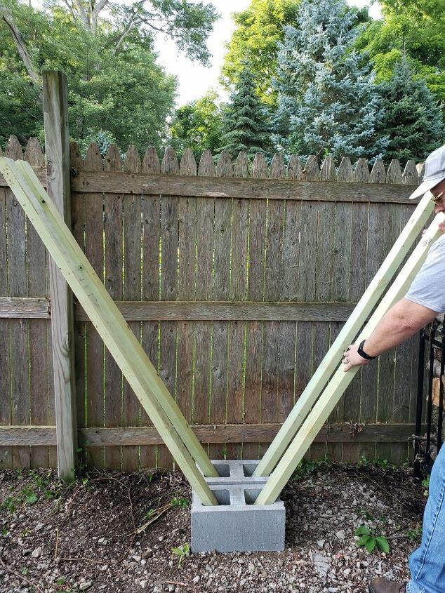 how to easily make a v shaped diy cinder block firewood rack, Inserting 2x4s into the cinder block openings