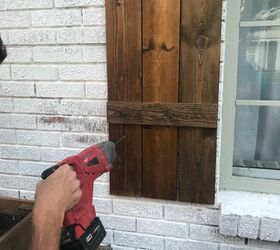 how to hang wood shutters on brick, drill going into wood shutter on white brick house
