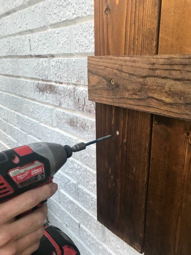 colgando persianas de madera en el ladrillo