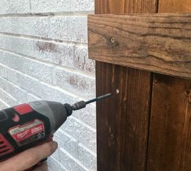 how to hang wood shutters on brick, drill inserting anchors into brick through wood shutter