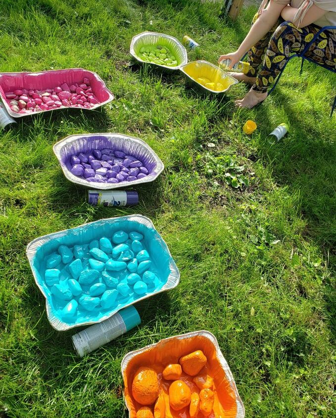 how to make diy rainbow river rocks for a magical yard decor idea, Spraying rocks with bright colored paint