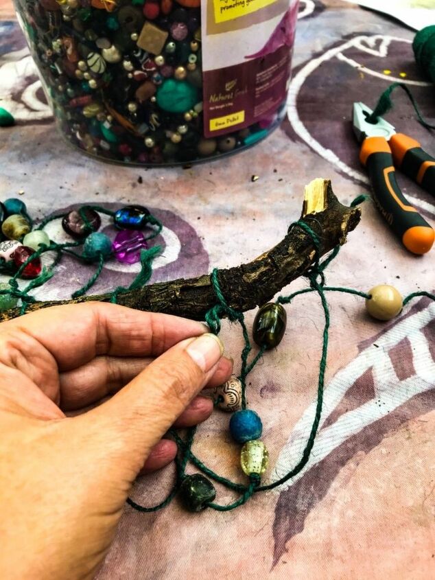 how to make a beautiful beaded branch mobile to brighten up your home, Knotting strings of beads to a branch