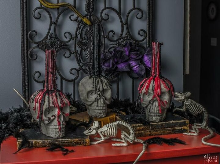 s 17 spooky halloween decor ideas that will scare your guests, Faux concrete skull candle holders