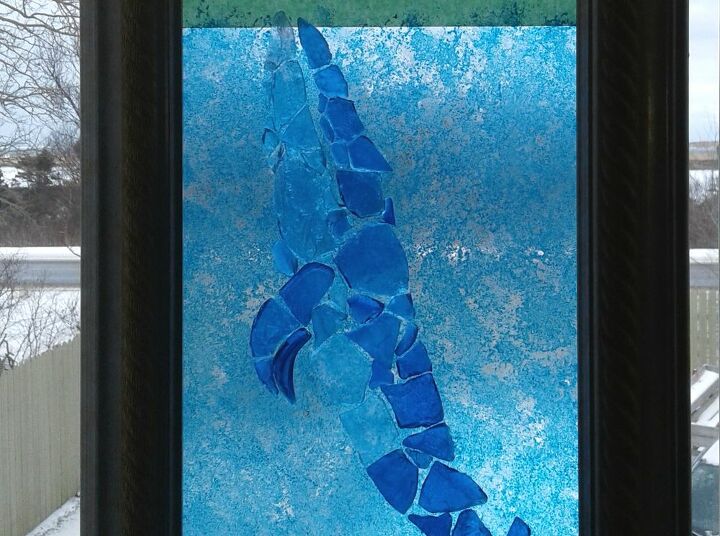 marco de mosaico de la ballena azul, Sostenida contra la ventana