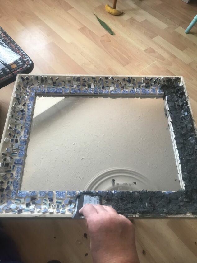 how to use up your broken china to decorate a mirror frame, Spread Black Grout onto china