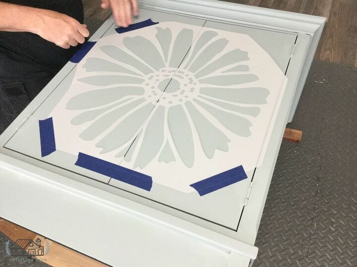 accent cabinet makeover, Taping Stencil to Front of Cabinet