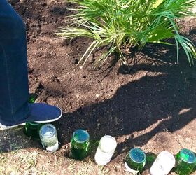 how to use your old glass bottles to create nice flower bed border, Push bottles into ground