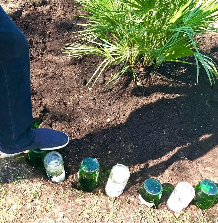 how to use your old glass bottles to create nice flower bed border, Push bottles into ground