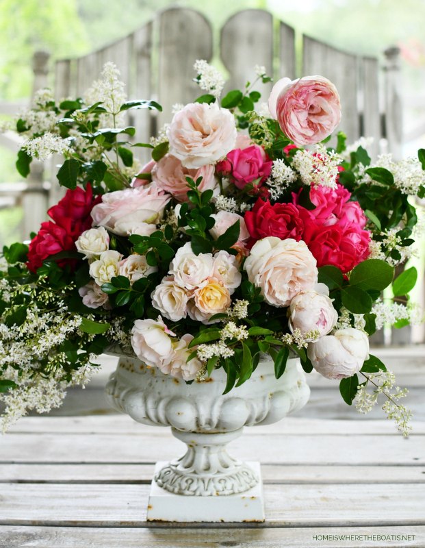 crie um arranjo de flores com rosas e folhagens do jardim