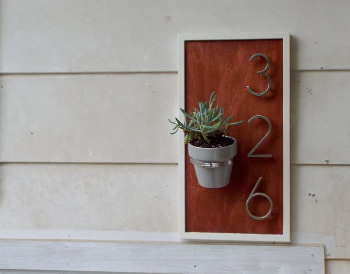 9 sleek house number ideas that ll turn heads on your block, Use a large pipe clamp to add a little flower pot