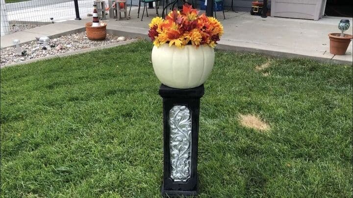 decoracin de jardn con calabazas para halloween, Maceta de calabaza con flores sobre columna pintada