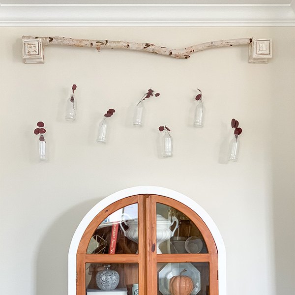 s 16 magazine worthy fall mantel ideas, Install whimsical bottle and birch wood wall art above your mantel