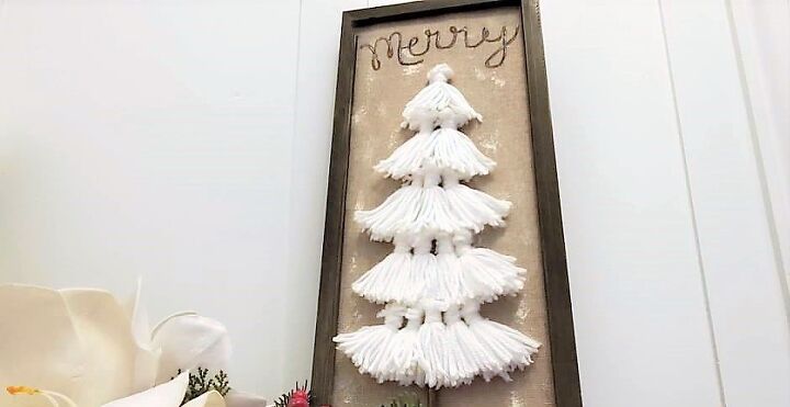 s 15 unexpected ways to sprinkle christmas cheer around your home, Go boho with a whimsical tassel Christmas tree on a burlap plaque