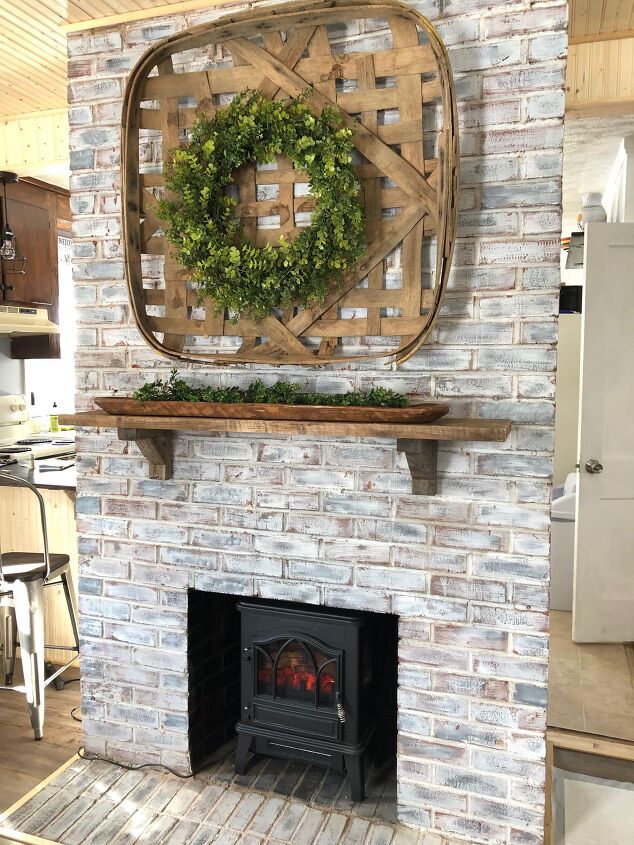 s 20 fireplace makeovers that will get your home in shape for the cold, Restore an old brick fireplace with whitewash and a walnut wood hanging mantle