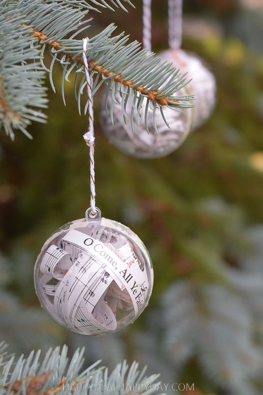 s 25 new christmas ornament ideas that we re totally obsessed with, Fill clear ornaments with strips from your favorite Christmas carols