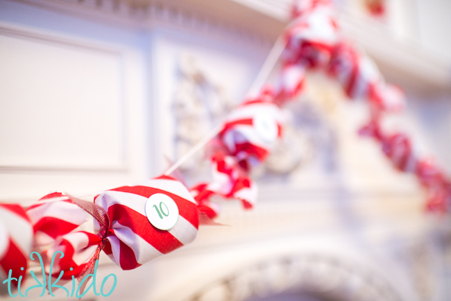 s 19 gorgeous ways to style your mantel for christmas, Start the countdown with a peppermint stripe Advent calendar garland