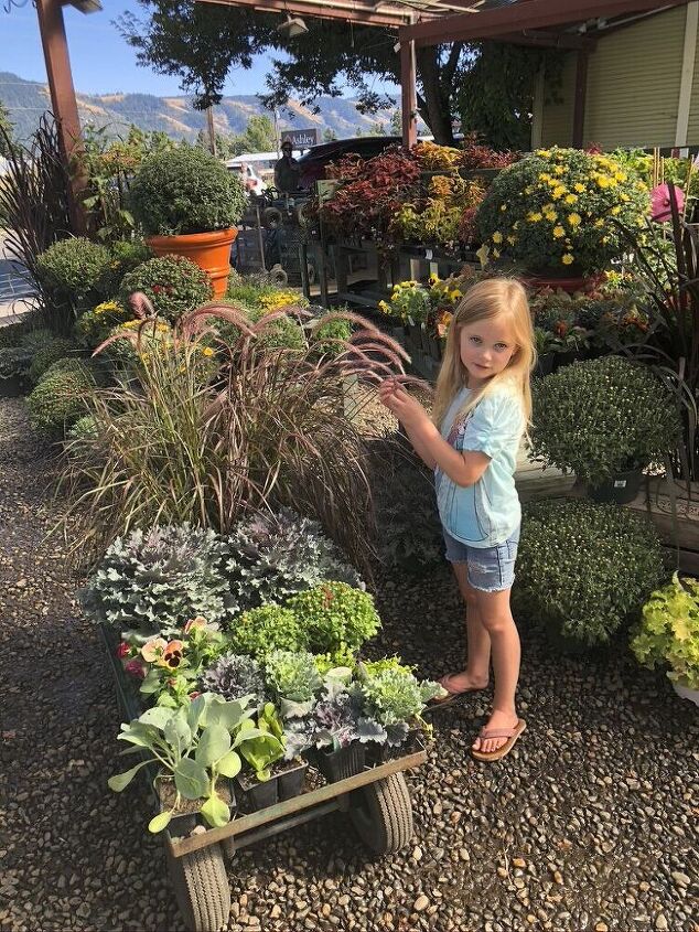 cmo decorar tus jardineras de otoo, Mi hija de pie junto a nuestras plantas que est bamos a punto de comprar en Good News Gardening