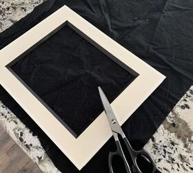 Lay an empty picture frame on a piece of old fabric for this unique accent