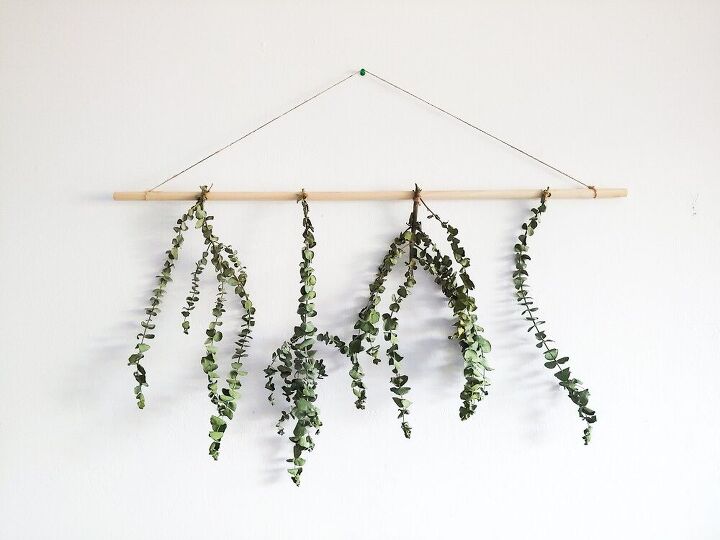 s 20 creative ways to give your home a boho vibe, Tie eucalyptus branches to a dowel for a natural wall hanging