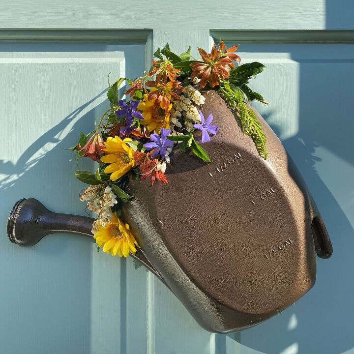 s 13 spring door ideas that ll make the neighbors stop and stare, Fill a water jug with bright flowers for colorful door decor