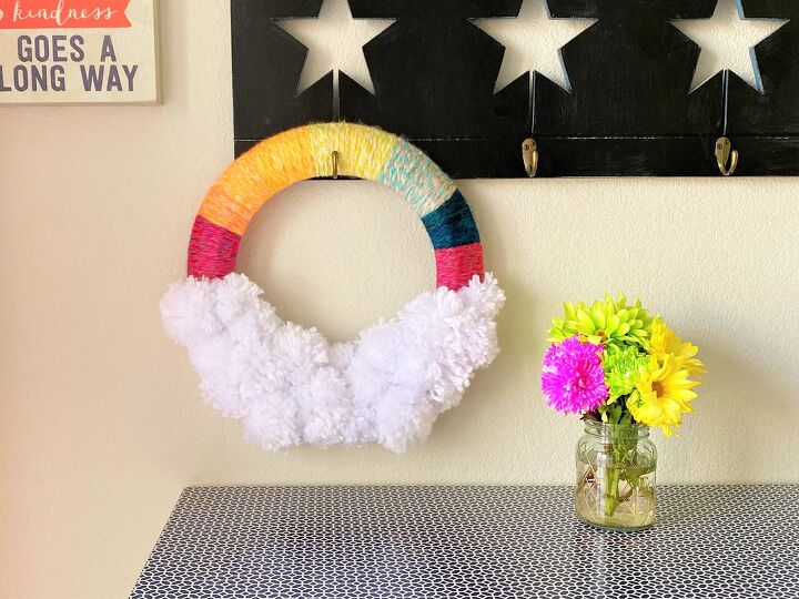s make your space a cheery haven with 15 pom pom diys, A rainbow wreath with chunky yarn