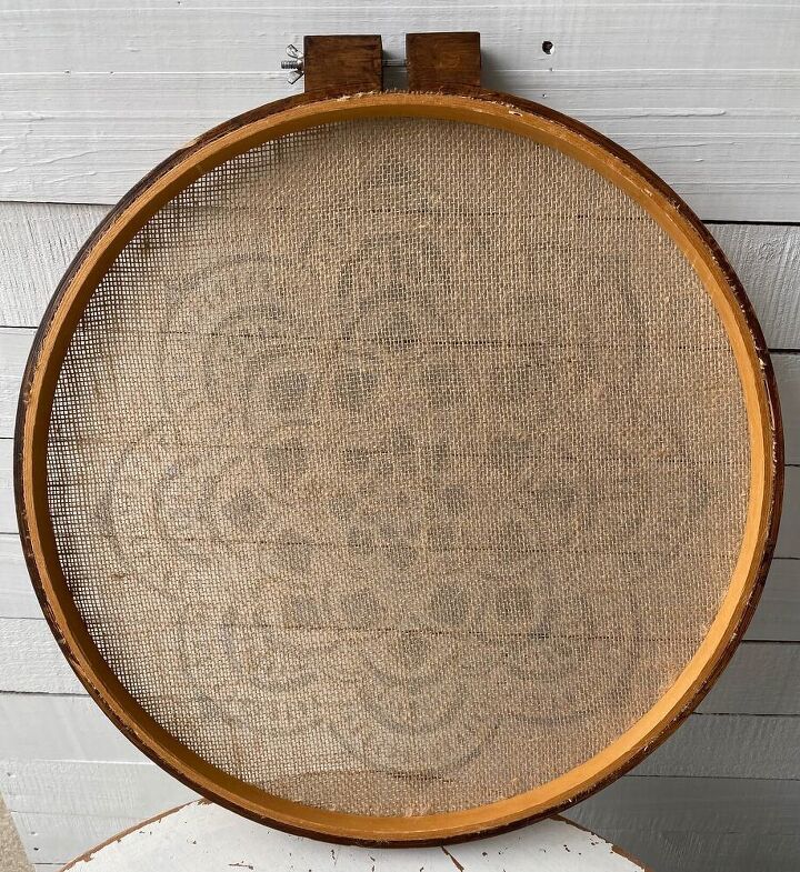 a thrifted wooden quilt hoop frames a stenciled mandala