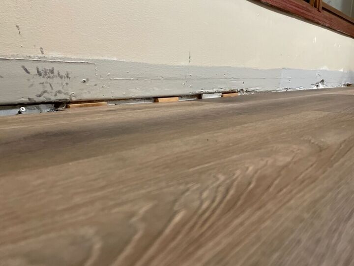 use caulking fill floor gaps and liquid nails to re adhere baseboards
