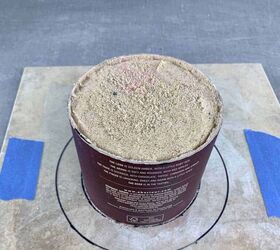 She cuts a whiskey canister in half and then packs it with sand for this pretty porch idea