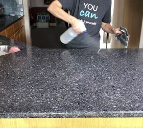 how to quickly clean your house from top to bottom, Person spraying countertop