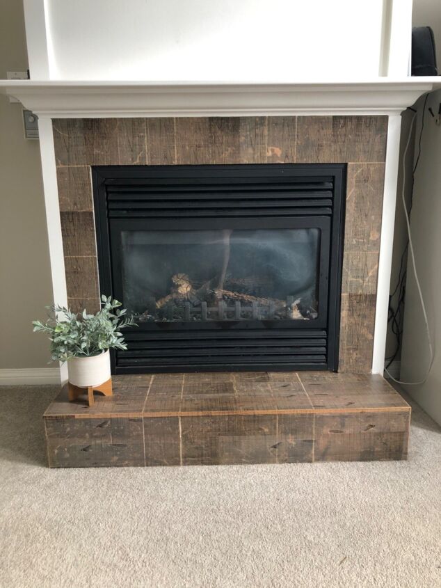 s 15 ways to update the fireplace you can t stand to look at anymore, Apply wood tile stickers to it