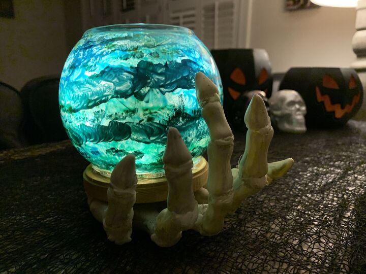 mano de esqueleto sosteniendo la bola de cristal