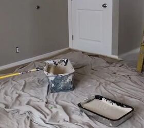a step by step guide on how to paint a room, room covered in a drop cloth and paint bucket